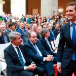 Pablo Casado (d) pasa por delante del e xpresidente de la Comunidad de Madrid, Angel Garrido (sentado-i), en las fiestas del año pasado