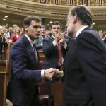 El líder del PP y presidente del Gobierno en funciones, Mariano Rajoy (d), es felicitado por el líder de Ciudadanos, Albert Rivera, tras ser investido hoy presidente del Gobierno