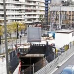 El pozo de obra de Lesseps ocupa prácticamente la mitad de la parte ajardinada de la plaza, donde, además, también es muy visible la grúa metálica de la línea 9.