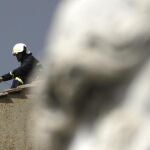 Unos bomberos colocan la chimenea en el tejado de la Capilla Sixtina por donde se podrá ver la fumata blanca.