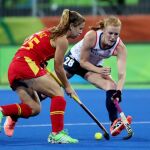 La jugadora española Alicia Magaz (i) disputa la bola con la británica Nicola White (d), durante el partido de cuartos de final de hockey sobre césped