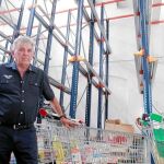 El presidente del Banco Solidario de Alimentos, Jaime Serra, posa frente a las estanterías vacías del almacén valenciano. Necesitan donaciones de comida para seguir con su labor solidaria
