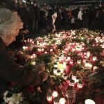 Una mujer enciende una vela en el lugar del atentado