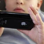 Un niño asiático utiliza un iPhone
