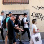 Unos turistas pasean por delante de una de las fachadas más castigadas