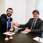 El expresidente de la Generalitat Carles Puigdemont (d) estrecha la mano del presidente del Parlamento autónomo, Roger Torrent, durante su reunión en Bruselas