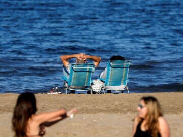 Imagen de archivo de varias personas disfrutan en la playa de la Malvarrosa del buen tiempo / Foto: Efe
