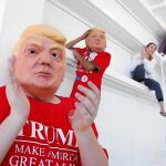 Unos niños usando máscaras con el rostro de Donald Trump escuchan al candidato republicano en un mitin en Carolina del Norte el sábado