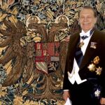 El escritor Manuel Muñoz Hidalgo, tras la Investidura, posando junto al tapiz que contiene el escudo de Carlos V