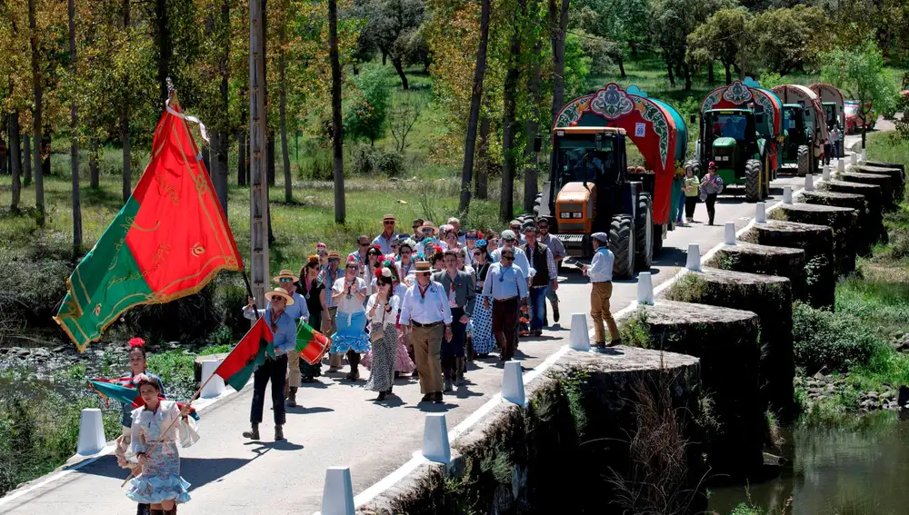 Las peñas romeras cruzan el Puente Viejo que conduce a Lugar Nuevo, donde paran a comer en su camino al Cerro del Cabezo, durante la Romería de la Virgen de la Cabeza, en Andújar / Fotos: Efe