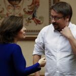La vicepresidenta del Gobierno, Soraya Sáenz de Santamaría, conversa con el diputado de Unidos Podemos, Francesc Domènech, antes de su comparecencia hoy ante la Comisión Constitucional
