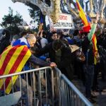 Un grupo de independentistas derriba las vallas que protegen la puerta principal de acceso a la cámara catalana /Efe