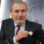 El ministro de Educación y Portavoz del Gobierno,Iñigo Méndez de Vigo, muestra una pin contra la violencia machista, durante la rueda de prensa del Consejo de Ministros