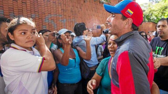 El ex candidato Henrique Capriles saluda a un grupo de venezolanos esperando en una larga fila, ayer