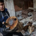 Un hombre carga con el contenedor que supuestamente se utilizó para esparcir gas cloro tras un ataque con cohetes en la zona siria de Al Ghouta oriental, en una foto de archivo