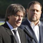 El presidente de la Generalitat, Carles Puigdemont (i), acompañado por el vicepresidente, Oriol Junqueras (d), en la ofrenda floral con motivo del 76 aniversario del fusilamiento de Lluis Companys