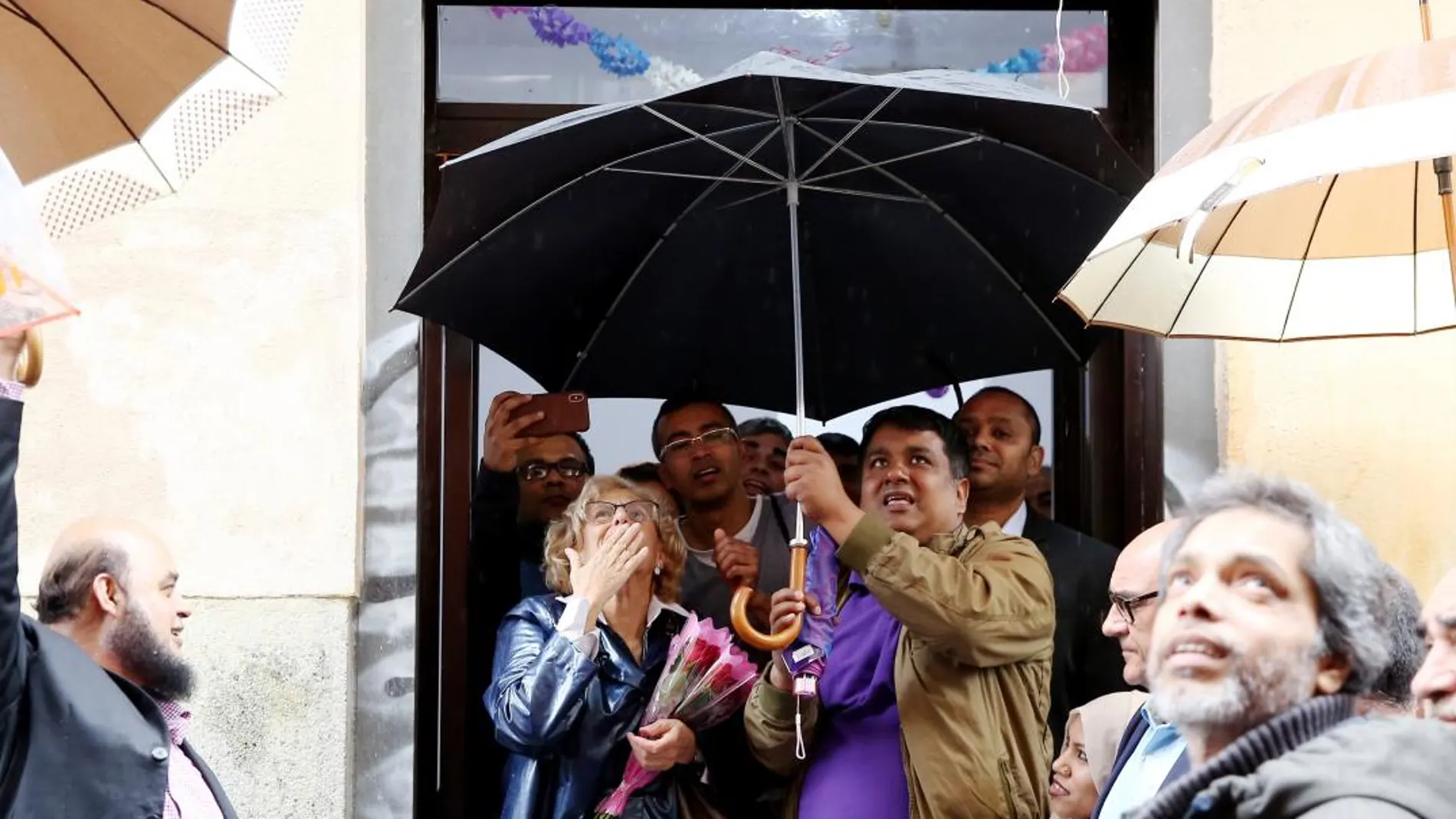 Carmena ayer con bangladesíes dedicados a la venta ambulante ilegal, a quienes quiere facilitar permisos para llevar a cabo su actividad