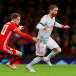 Sergio Ramos disputa un balón en presencia del galés Ramsey / Reuters