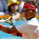 El tenista español Rafael Nadal golpea la pelota durante el partido de cuartos de final del Open de Madrid