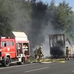 Bomberos junto al autobús calcinado