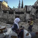 Niños sirios juegan en un carrusel durante el segundo día de la festividad musulmana Eid Al Adha en Douma