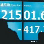 Varias personas observan la caída sufrida ayer por el índice Nikkei de la bolsa de Tokio (Japón)