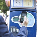 Un conductor pagando el parquímetro con el móvil