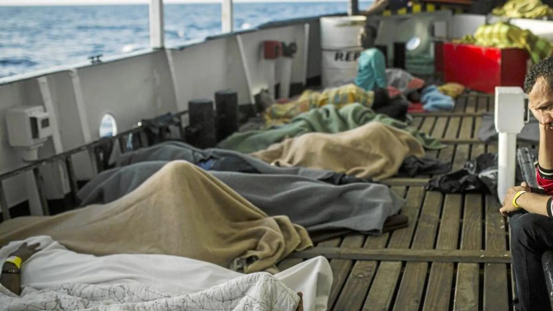 Varios migrantes yacen sobre una embarcación tras llegar irregularmente a España
