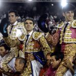 Los diestros José Tomás, David de Miranda (i) y Alberto López Simón (d) salen a hombros tras la corrida de la Feria de las Colombinas celebrada en la plaza de toros de Huelva.
