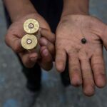 Un manifestante muestra un par de cartuchos de armas de fuego durante manifestación en contra del Gobierno venezolano.