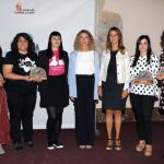 Foto de familia de la consejera Alicia García y y la directora general de la Mujer, Esperanza Vázquez, junto a las premiadas