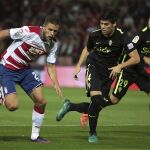 El delantero ucraniano del Granada Artem Kravets (i) regatea ante disputa el defensa del Sporting de Gijón Jorge Meré (d), durante el partido