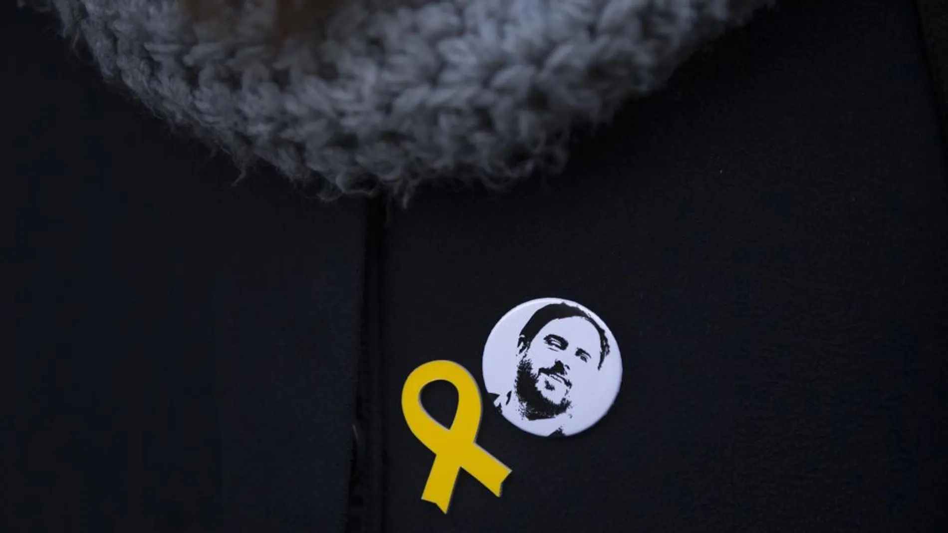 Una mujer con un pin de Junqueras junto al lazo amarillo