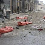 Cuerpos de varios fallecidos en el suelo, tras el impacto de una bomba en el barrio de Yeb al Quebeh en Alepo
