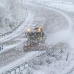 Un máquina quitanieves trabaja bajo una intensa nevada en la A-62