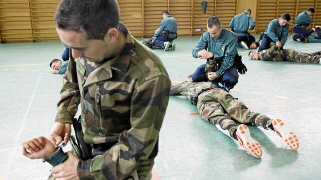 Las clases de intervención operativa son conjuntas. Guardias civiles –de verde– y gendarmes franceses –de camuflaje– practican la forma de reducir y engrilletar a un delincuente. Fotos: Jesús G. Feria
