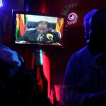 Varias personas siguen por televisión el mensaje de Mugabe