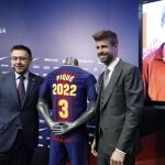 El central del FC Barcelona Gerard Piqué posa con el presidente del club, Josep María Bartomeu, tras firmar su ampliación de contrato con el club azulgrana, en el que permanecerá cuatro temporadas mas.