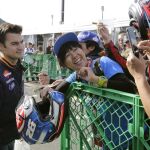El piloto español de MotoGP del equipo Repsol Honda Dani Pedrosa posa con fans a su llegada al circuito.