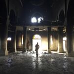 Un soldado camina por la iglesia de Al Tahira (Inmaculada), destrozada por el grupo yihadista Estado Islámico, en la de la localidad de Al Hamdaniya