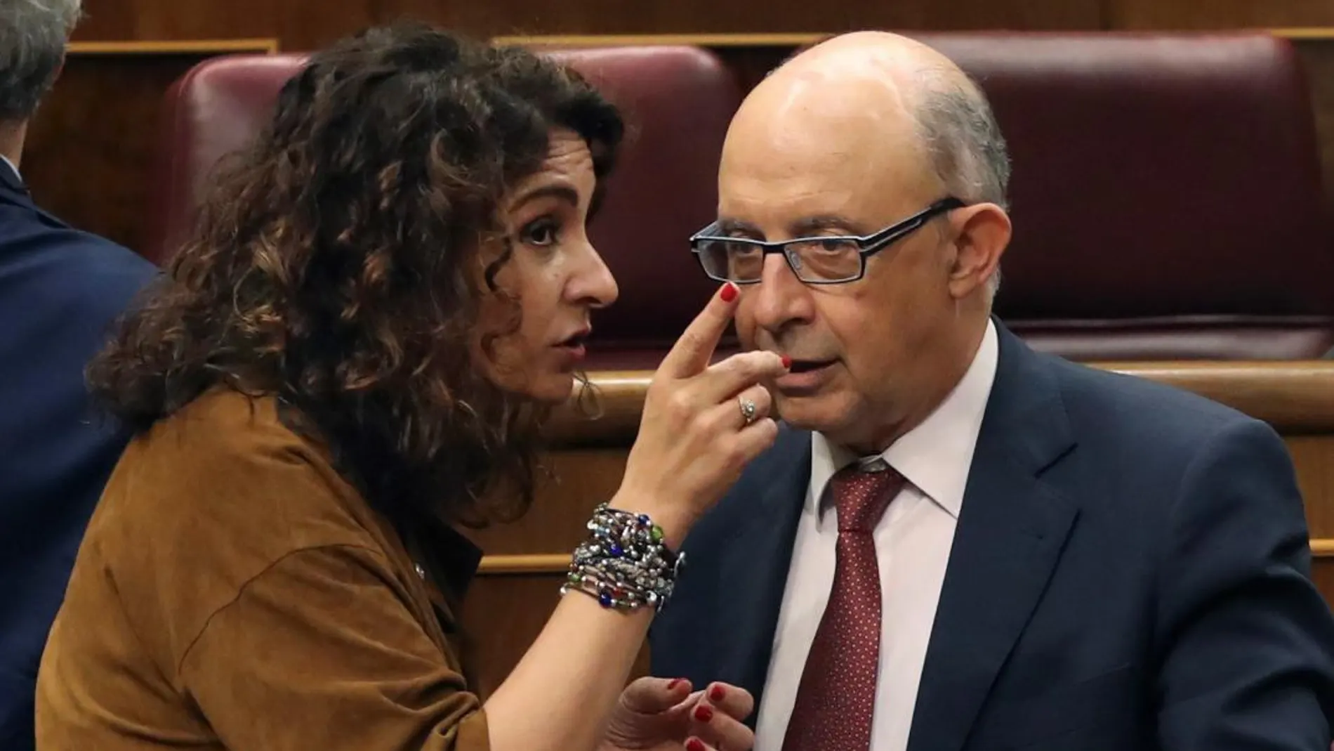 La ministra de Hacienda María Jesús Montero (i) conversa con el diputado popular y exministro Cristóbal Montoro la pasada semana en el Congreso. . EFE/Ballesteros