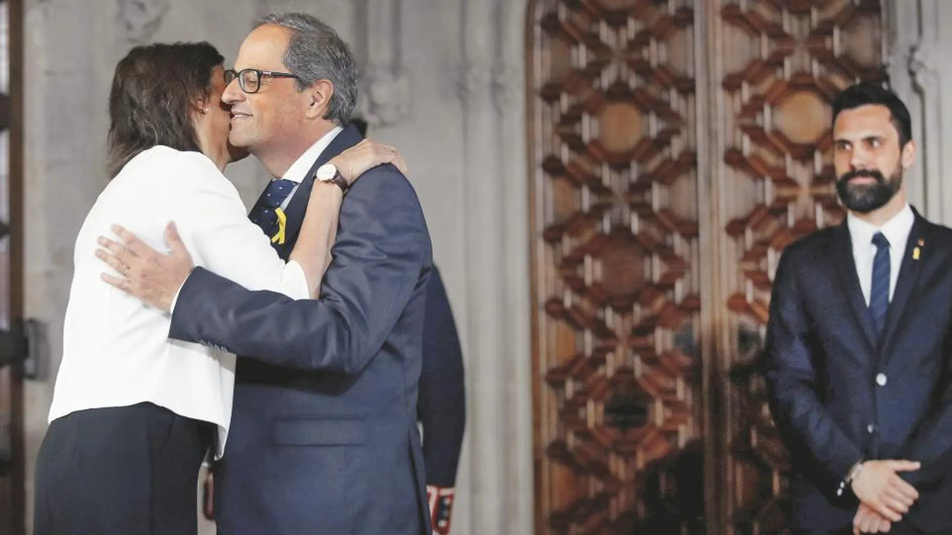 Quim Torra, acompañado del presidente del Parlament, Roger Torrent, saluda a su esposa después de tomar posesión como presidente de la Generalitat, ayer en Barcelona / Ap