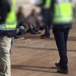 Imagen de los agentes custodiando a varios inmigrantes irregulares