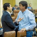 El líder del PP-A, Juanma Moreno, a la izquierda, conversa con el de Ciudadanos en la región, Juan Marín, en el Parlamento andaluz