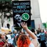 Una mujer protesta contra las mentiras del ultra en internet / Foto: Ap
