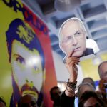 Varios opositores muestran la foto de Antonio Ledezma y de Leopoldo López durante un acto en Caracas