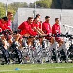 Los jugadores del Atlético trabajan sobre la bicicleta en el entrenamiento de ayer