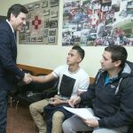 El consejero de Empleo, Carlos Fernández Carriedo, saluda a dos jóvenes que acaban de ser contratados