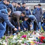 HOMENAJE A LAS VÍCTIMAS. Refugiados del centro de Tempelhof depositan flores por los fallecidos