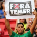 Un hombre con un cartel contra Temer durante un partido de fútlbol de Río 2016